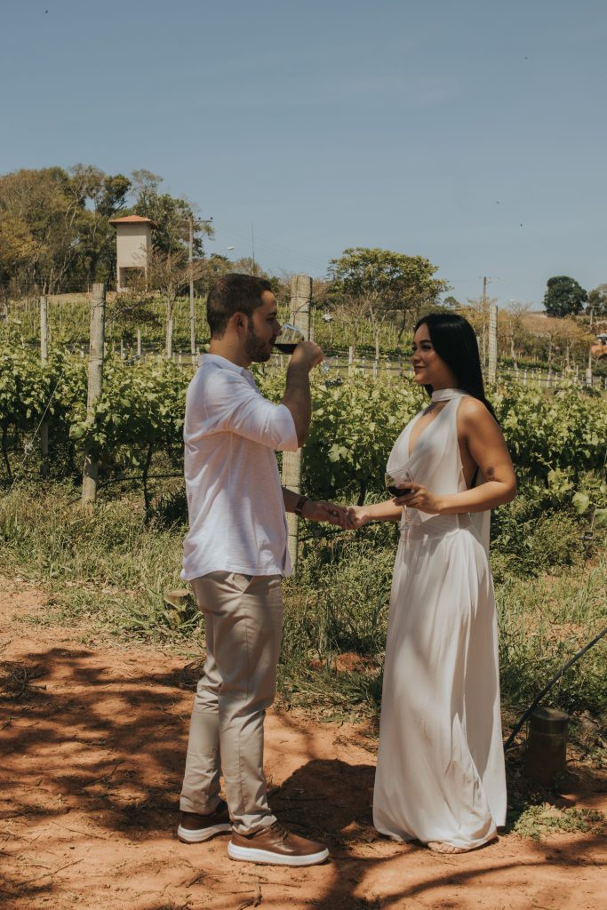 A couple enjoying wine together among grapevines