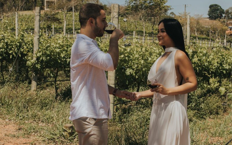 A couple enjoying wine together among grapevines